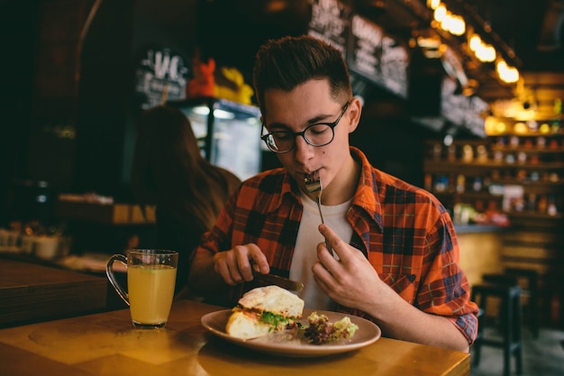 Homem está comendo em um restaurante e saboreando uma comida deliciosa