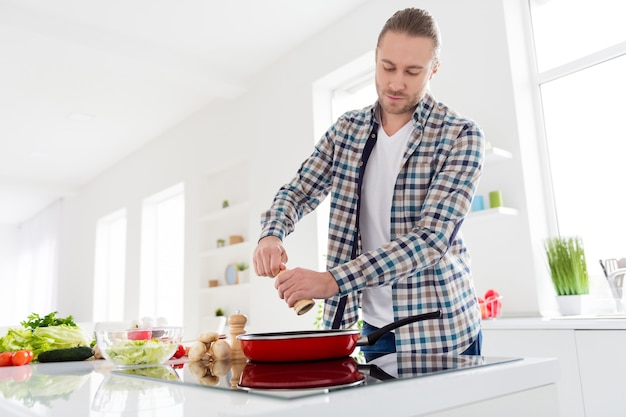 Homem está cozinhando em cozinha moderna