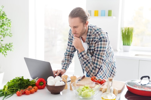 Homem está cozinhando em cozinha moderna