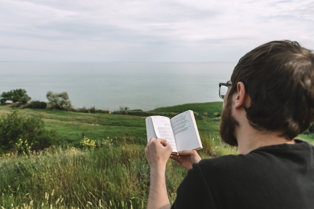 Homem está lendo um livro ao ar livre