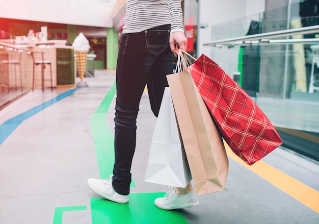 Homem está segurando sacolas de compras na mão esquerda