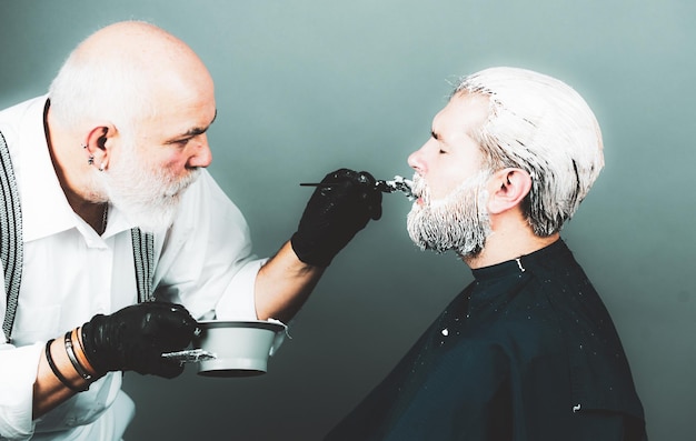 Homem estilista com tintura de cabelo e escova colorindo cabelo no salão Processo de um cara tingindo o cabelo no cabeleireiro