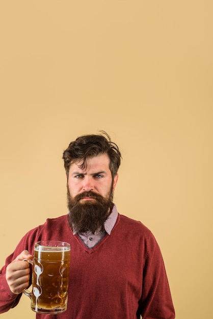 Homem estiloso com barba segura caneca de cerveja bebe álcool lazer e pessoas conceituam maus hábitos