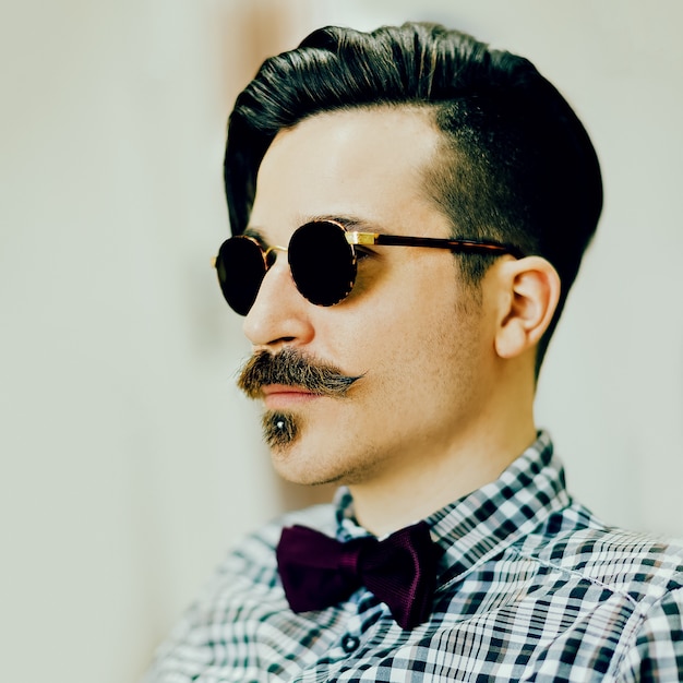 Homem estiloso com corte de cabelo na moda e bigode. Estilo retrô