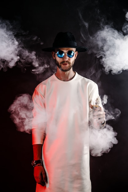 Foto homem estiloso no chapéu vaping