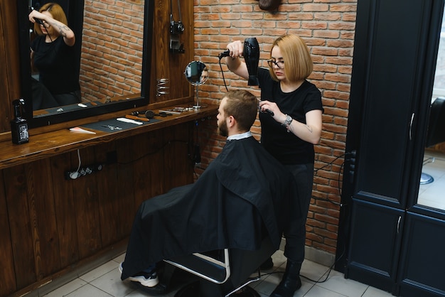 Homem estiloso sentado na barbearia, cabeleireiro, cabeleireiro