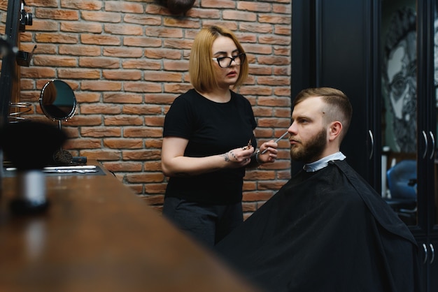 Homem estiloso sentado na barbearia, cabeleireiro, cabeleireiro