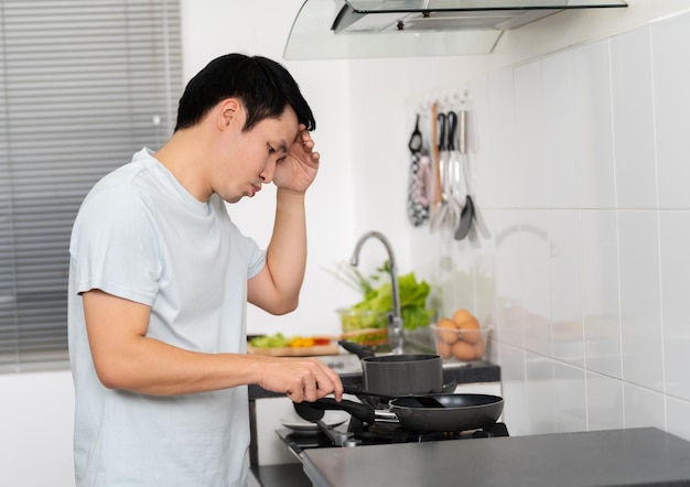 Foto homem estressado cozinhando e preparando comida na cozinha em casa