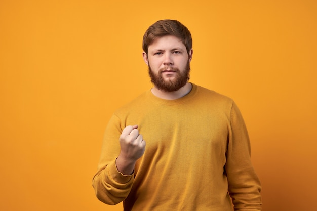 Homem estrito raivoso com barba espessa, estando furioso, expressa advertência e ameaça, mostra sua força ou determinação