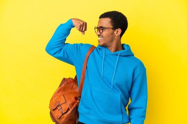 Foto homem estudante afro-americano sobre fundo amarelo isolado fazendo gestos fortes