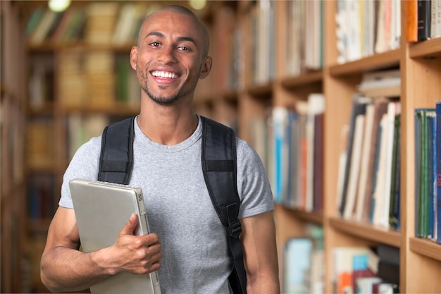 Homem estudante com laptop sorrindo para a câmera