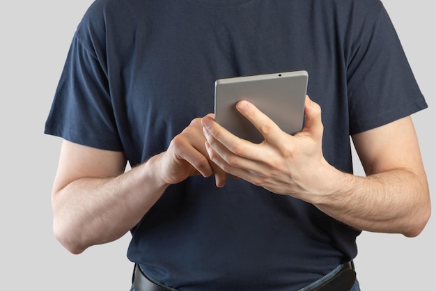 Homem europeu com um tablet nas mãos sobre um fundo cinza isolado