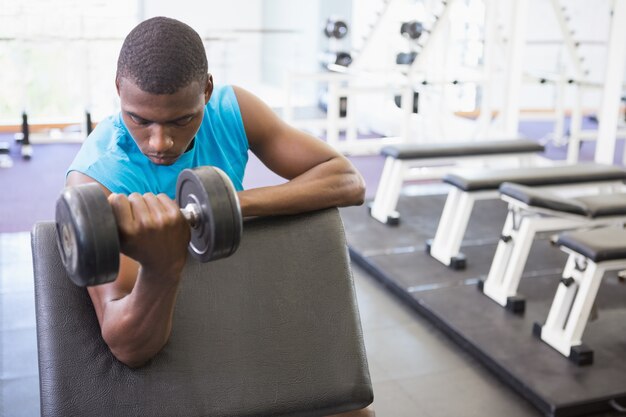 Homem exercitando com dumbbell na academia