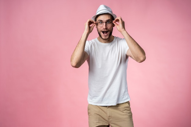 Homem expressivo feliz surpreso, isolado em rosa.