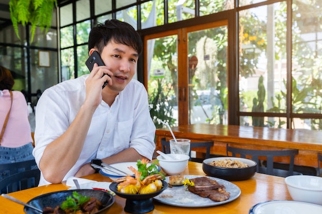 Homem falando ao celular em restaurante