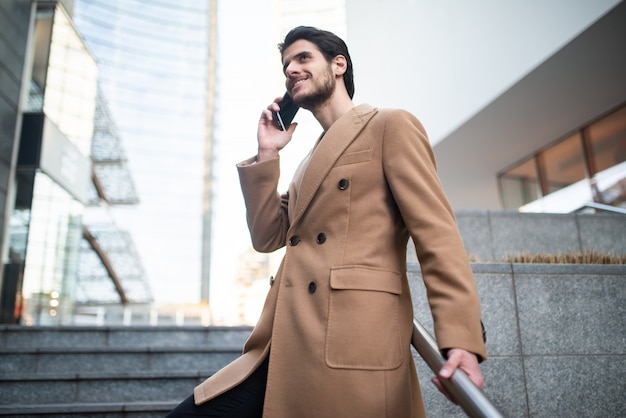 Homem falando ao telefone enquanto descia uma escada