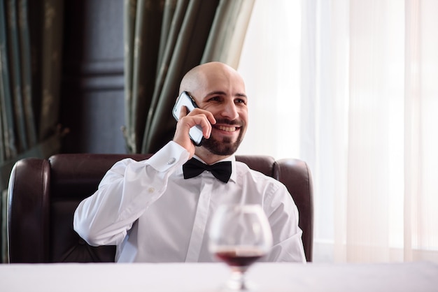 Homem falando ao telefone no restaurante.