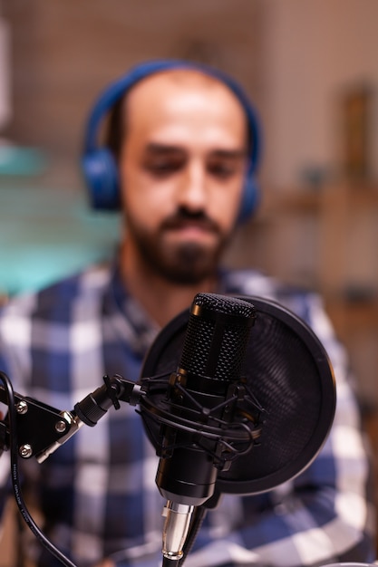 Foto homem falando sobre sucesso em seu podcast usando tecnologia de gravação profissional em estúdio doméstico. creative online show. produção no ar, transmissão pela internet, transmissão de conteúdo ao vivo.