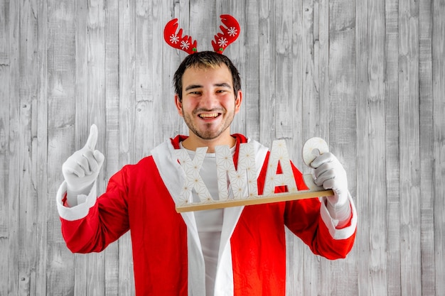 Foto homem fantasiado de papai noel com uma carta de natal