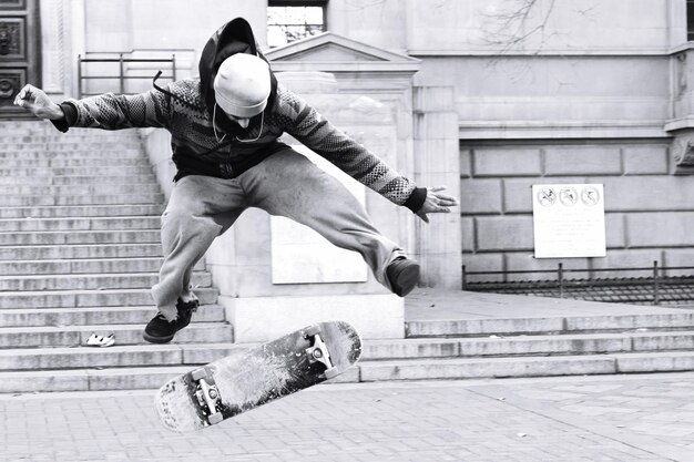 Foto homem fazendo acrobacia com skate