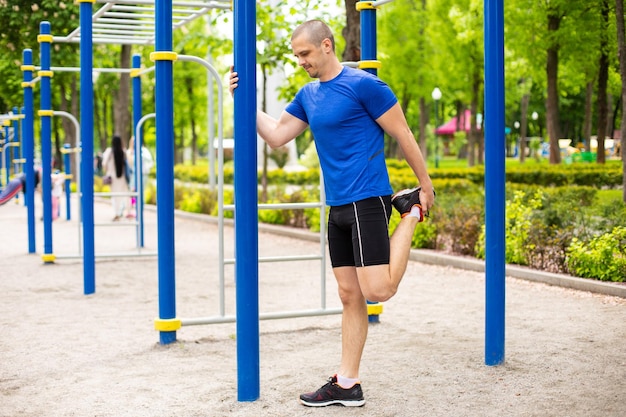 Homem fazendo alongamento após treino de corrida no parque. Ao ar livre após o alongamento de pernas de treino