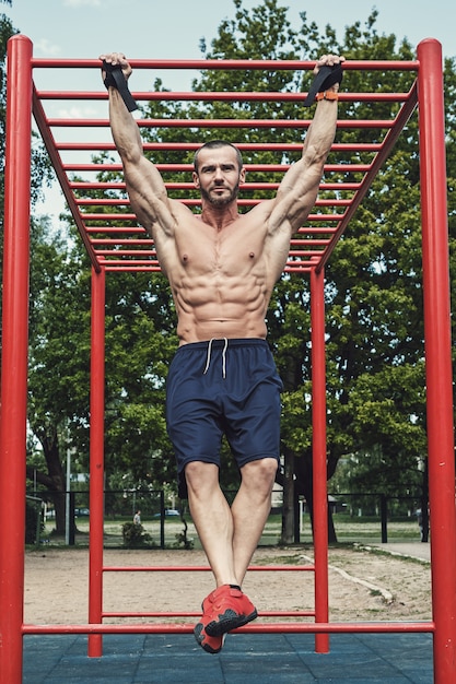 Homem fazendo flexões na barra horizontal