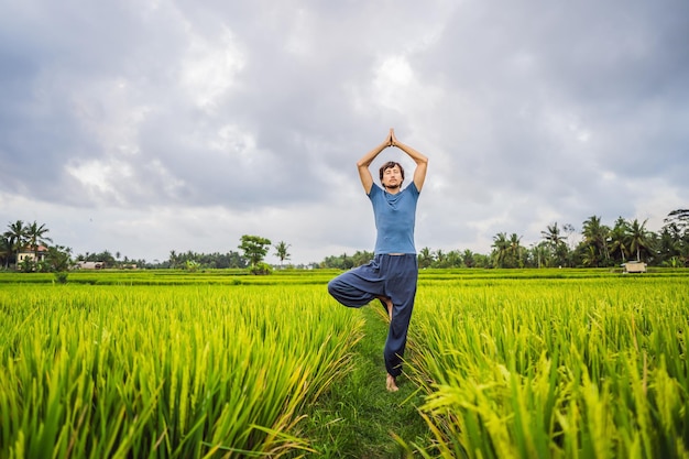 Homem fazendo ioga em um campo de arroz
