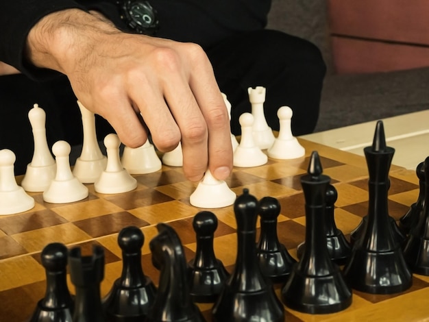 homem fazendo o primeiro movimento com peão branco no xadrez