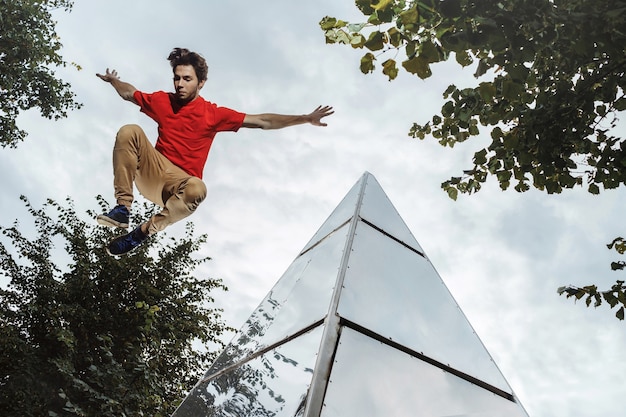 Homem fazendo parkour na cidade. Atleta praticando corrida livre.