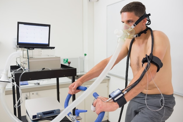 Foto homem fazendo teste de fitness na bicicleta de exercício