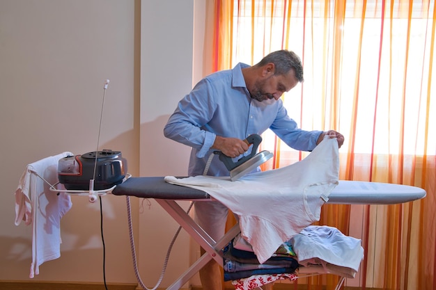 Homem fazendo trabalhos domésticos com o ferro