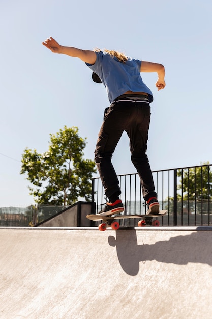 Homem fazendo truque no skate full shot