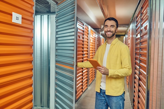 Homem feliz abrindo a porta para o contêiner do armazém