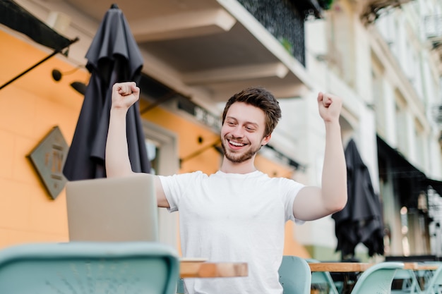 Homem feliz animado com sua vitória no laptop