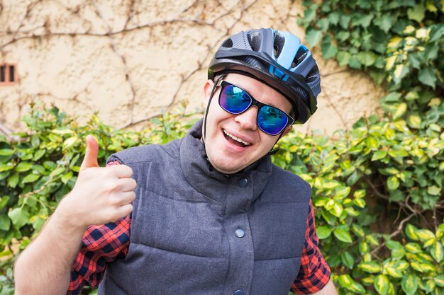 Homem feliz aparece com o polegar no jardim