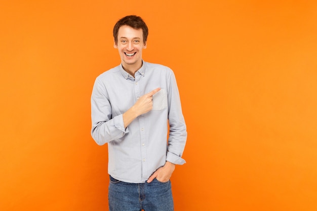 Homem feliz apontando o dedo para o espaço da cópia e sorrindo