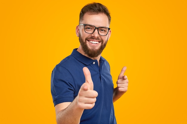 Homem feliz apontando para a câmera com o dedo indicador