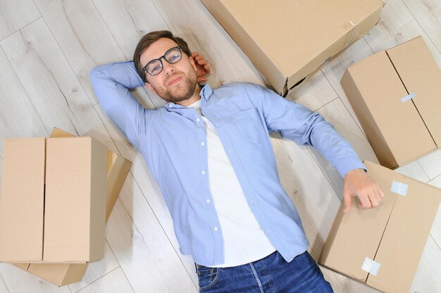 Homem feliz com caixa de papelão na nova casa