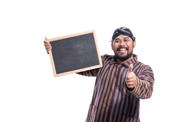 Homem feliz com camisa lurik tradicional javanesa, segurando um quadro-negro