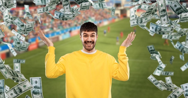 Homem feliz com mais dinheiro chove no campo de futebol
