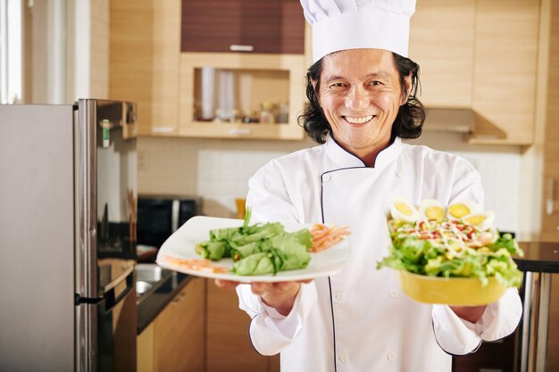 Homem feliz com pratos que ele cozinhou