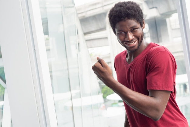 Homem feliz com retrato de sucesso de feliz sorrindo animado forte expressão de homem negro africano bem-sucedido e olhando para você modelo de homem negro africano adulto jovem