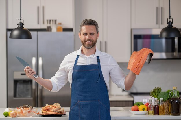 Homem feliz cozinhar salmão delicadeza peixe homem cozinhar delicadeza salmão no k itchen