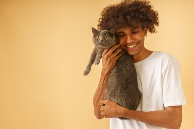 Foto homem feliz cuida de seu gato cinza