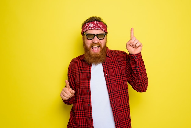 Homem feliz dançando com barba e bandana na cabeça