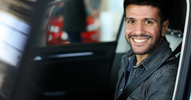 Foto homem feliz dentro de seu carro novo