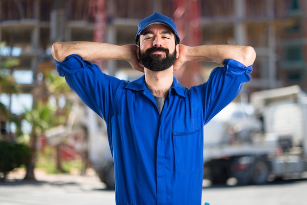 Homem feliz do encanador no fundo desenfocado