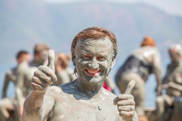 Homem feliz do retrato que toma banho de lama. Dalyan, Turquia