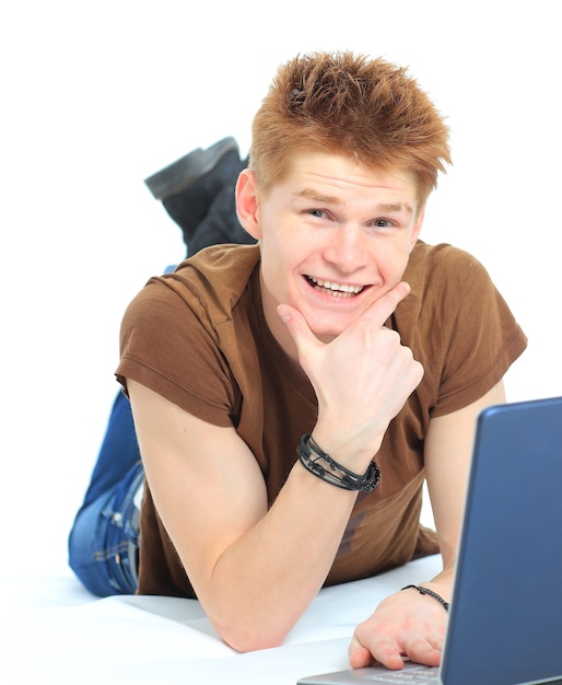 Homem feliz e bem-sucedido deitado no chão usando um laptop