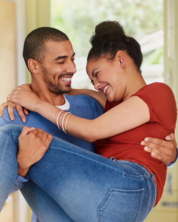 Foto homem feliz e mulher carregando na cozinha com amor cuidado e abraço na nova casa juntos sorriso casal e comemorar para casamento lua-de-mel e entusiasmado para se mudar para um apartamento em los angeles